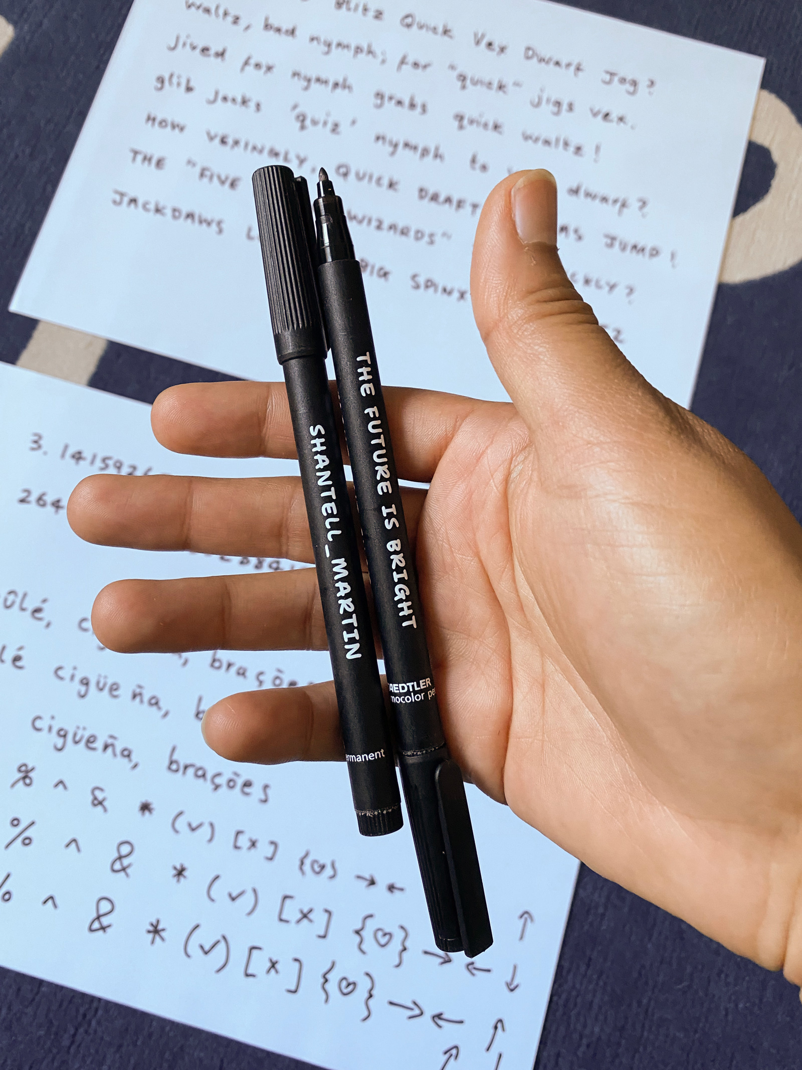 Shantell Martin holding a permanent marker, with writing samples in the background